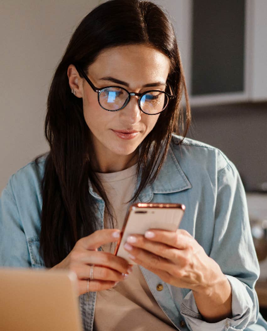 woman looks at her phone