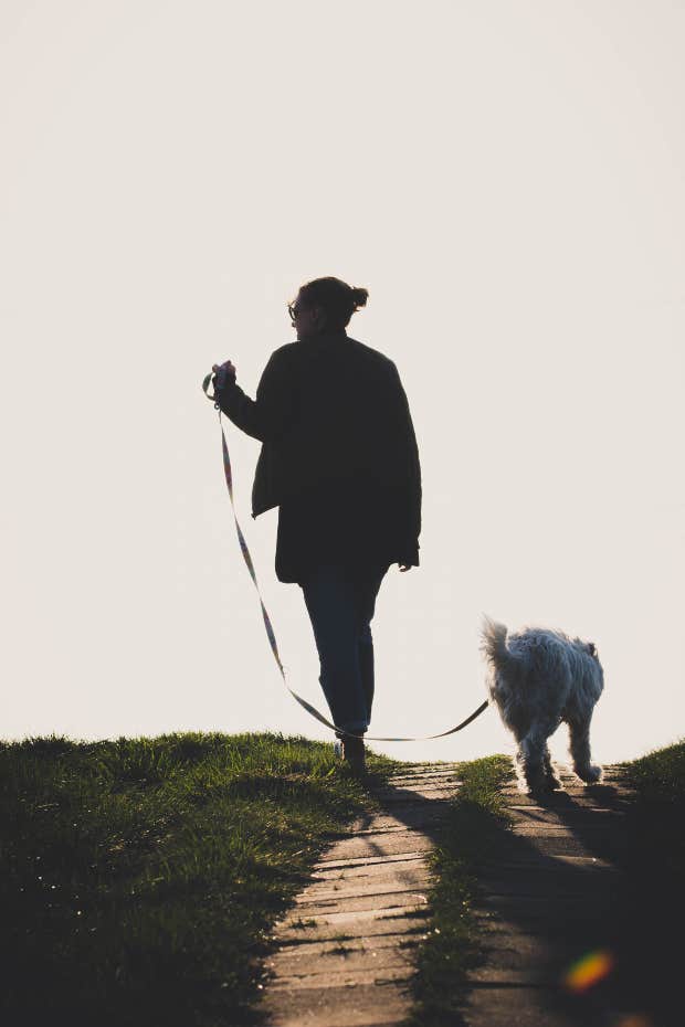 woman taking poor dog on walk