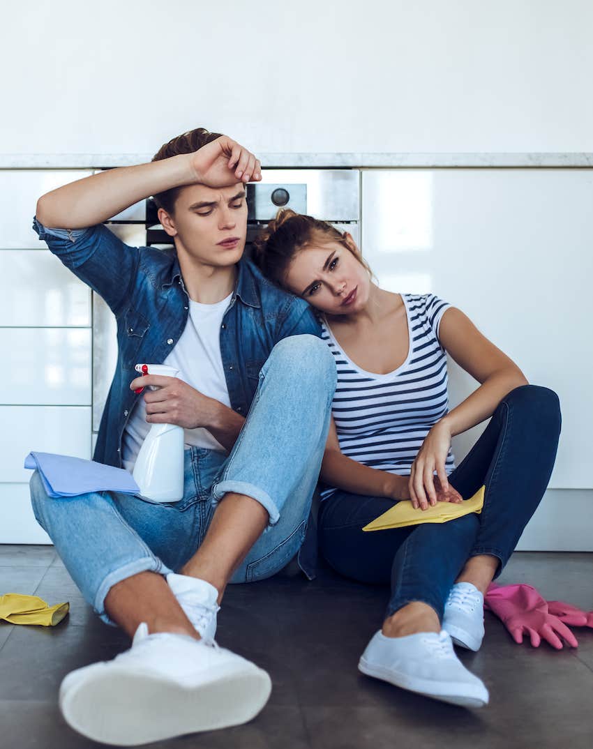 couple sitting on kitchen floor after cleaning
