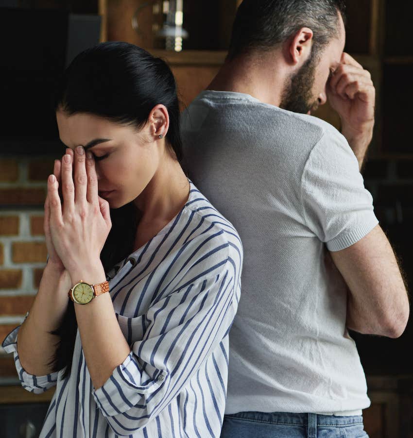 tense upset couple stand back to back