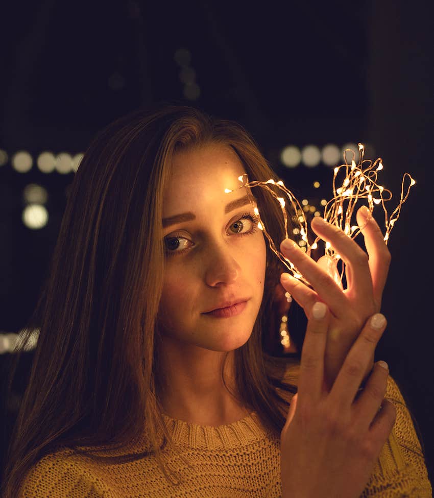 woman holding lights reminiscent of a crown 