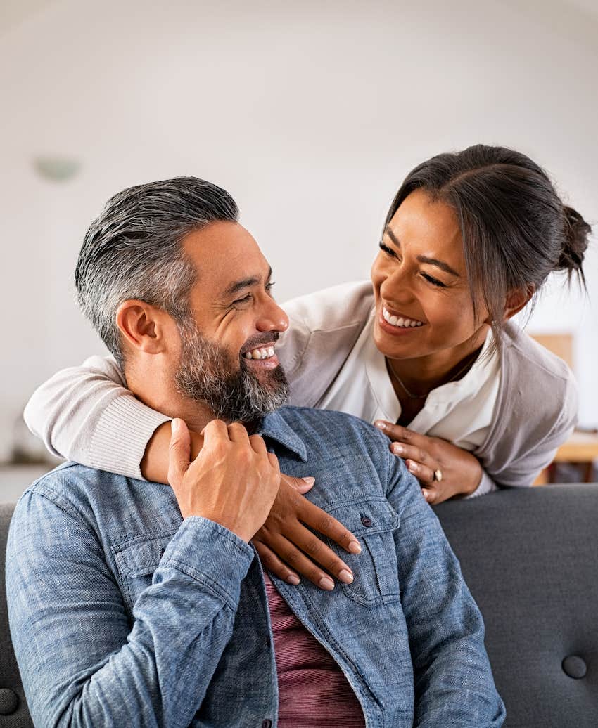 woman hugging her husband on the couch