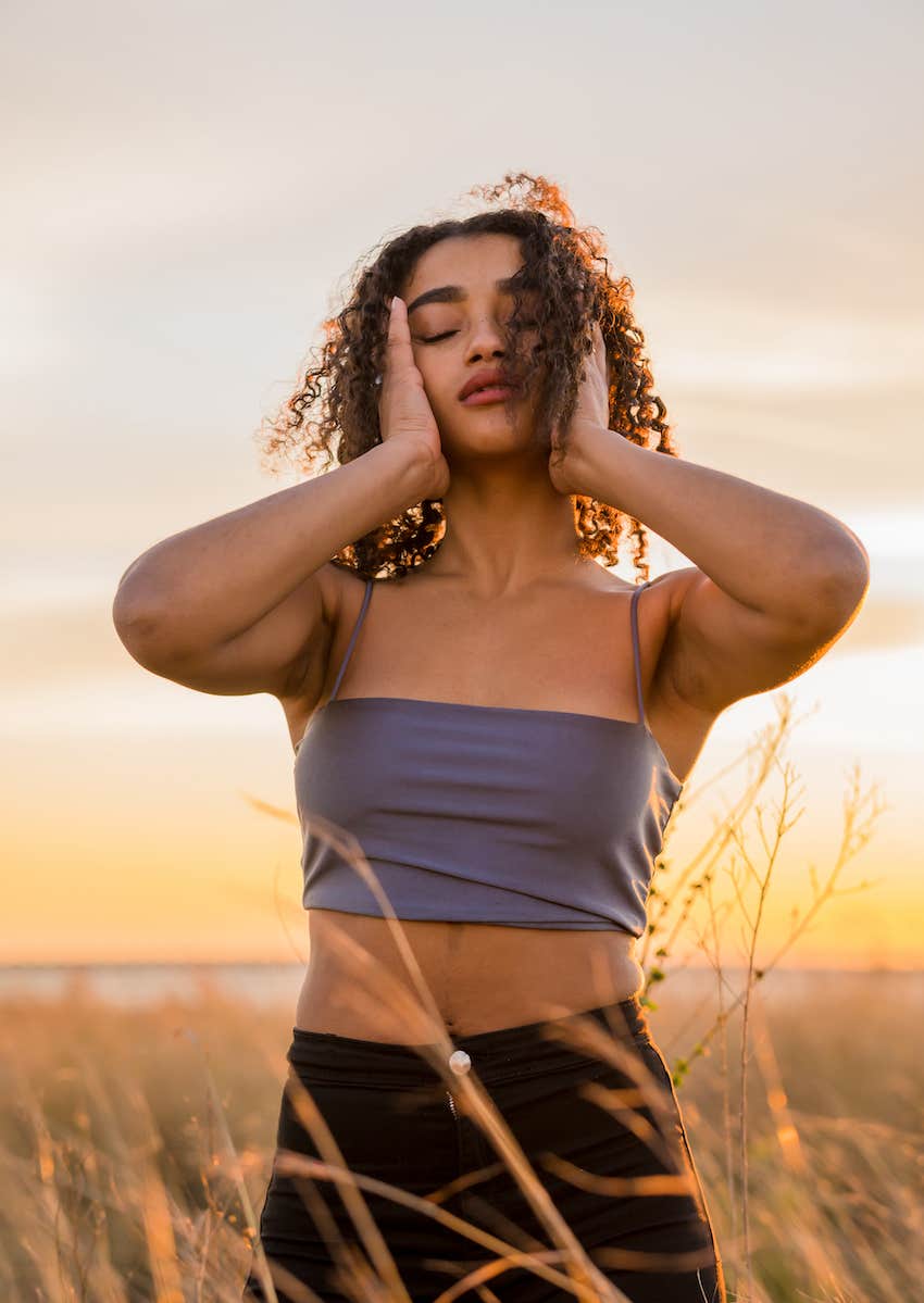 woman in field loving herself