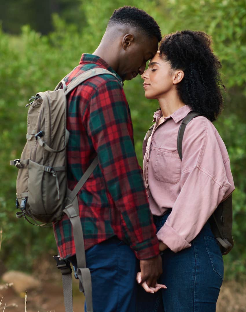 Affectionate couple standing with eyes closed on a hiking trail