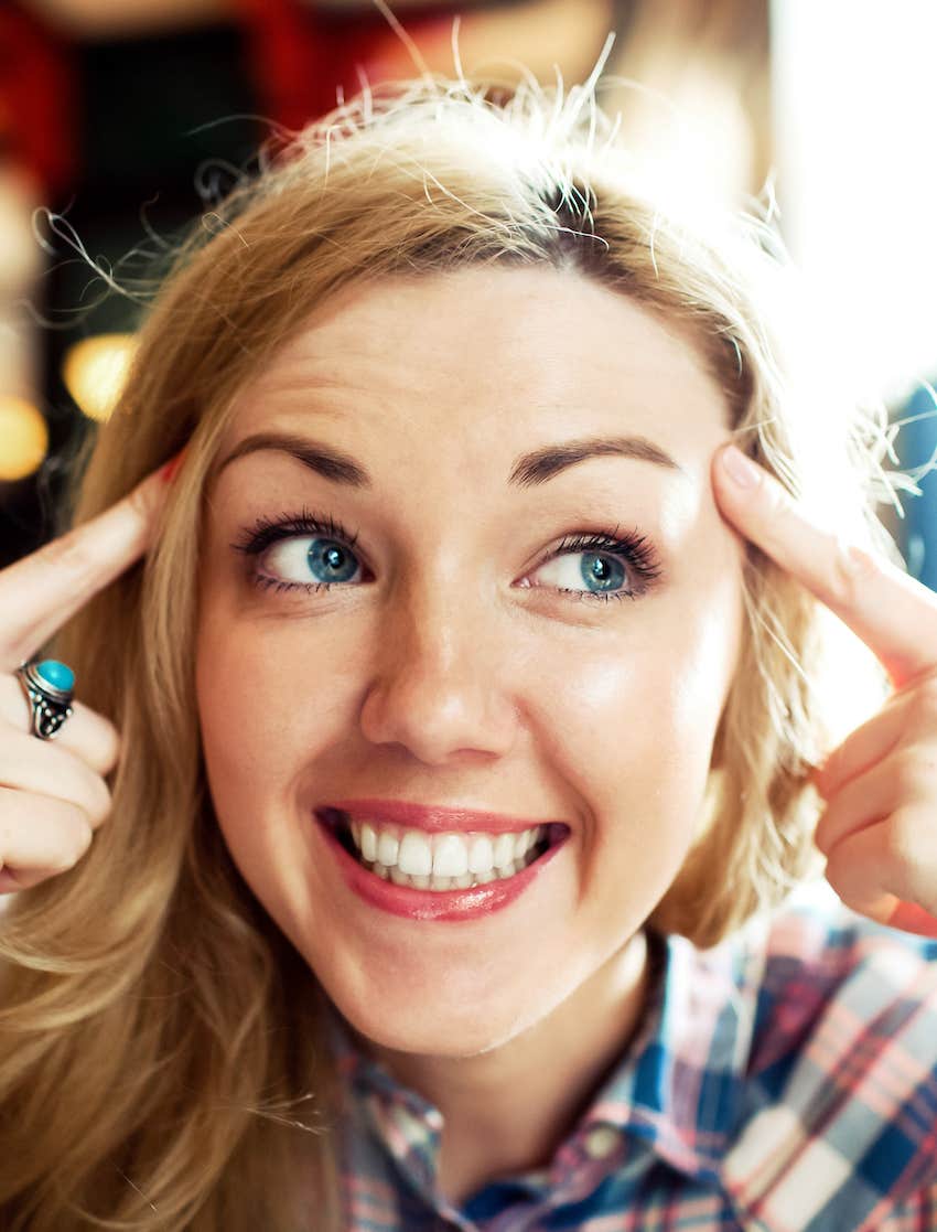 woman points to both sides of her head. 