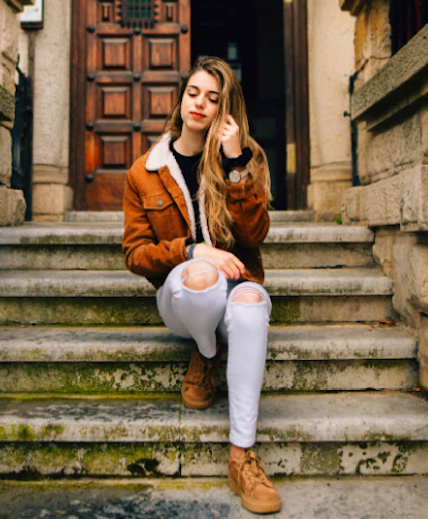 contemplative woman sits on steps