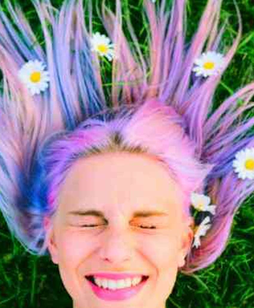 laying on the grass with daisies in her hair