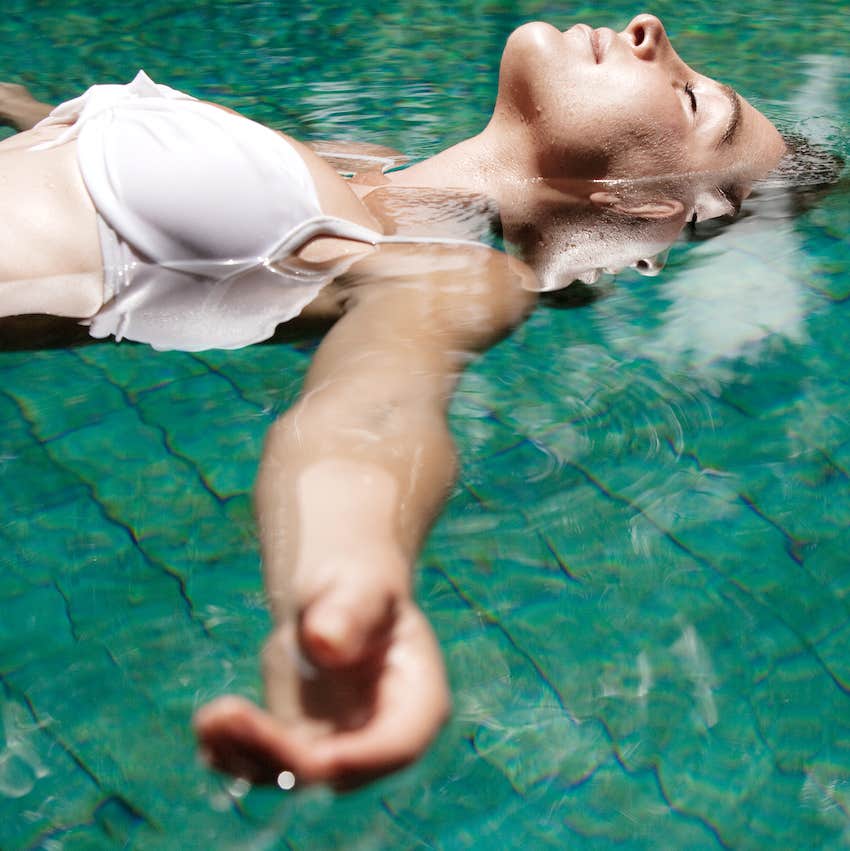 woman floating in water while in a swimming pool 