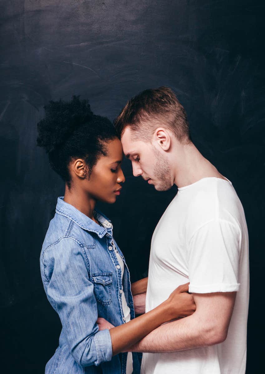 close couple stand forehead to forehead intimately 