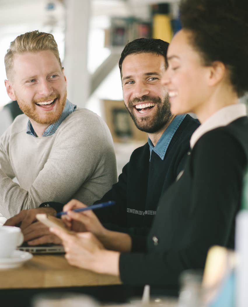 three people at a table, two people are attracted to the third