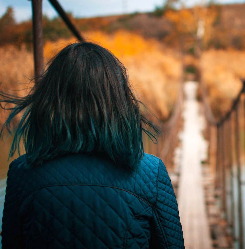 woman about to cross suspension bridge