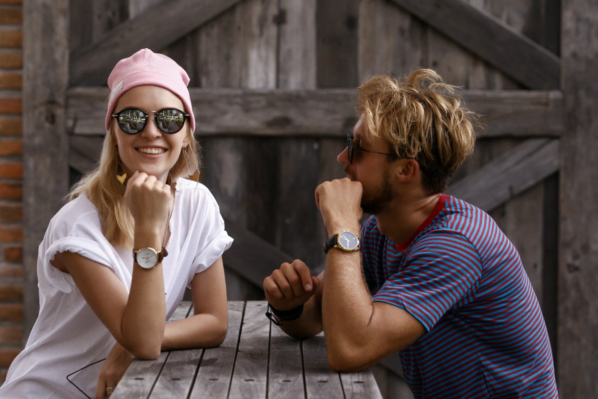 Man and woman sitting at a picnic table, comfortably talking 