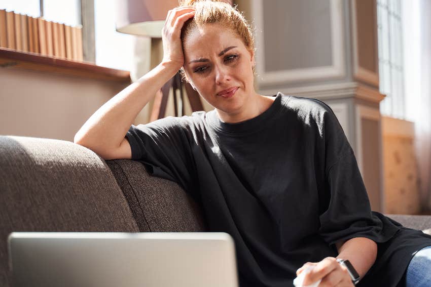 upset woman looking at laptop