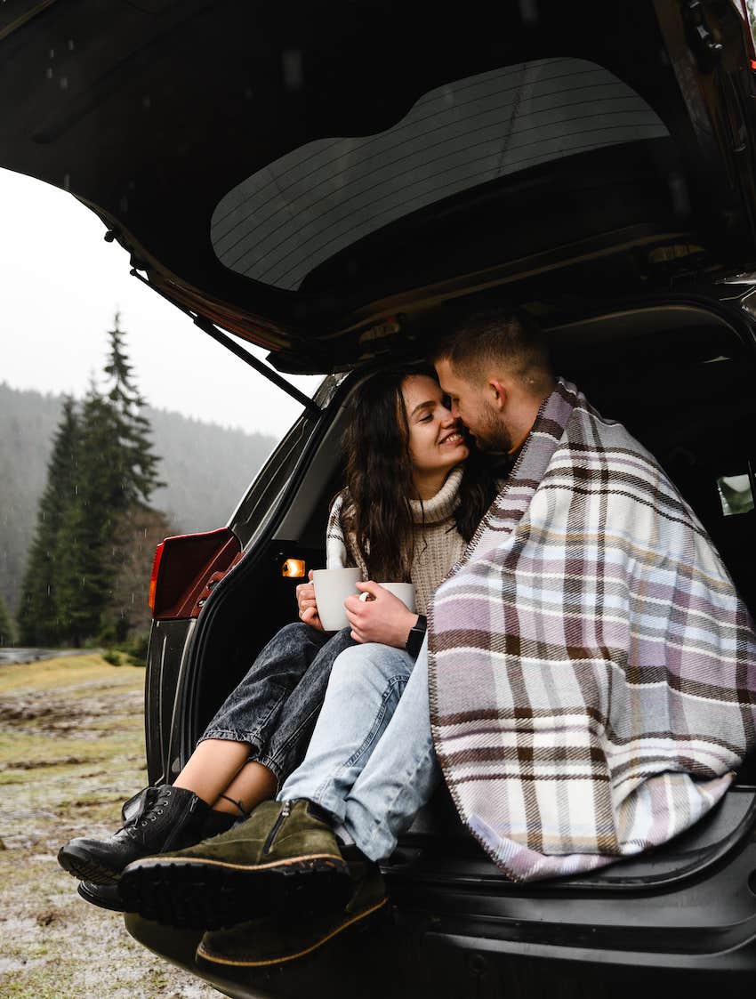 couple in love sits in the trunk of a car