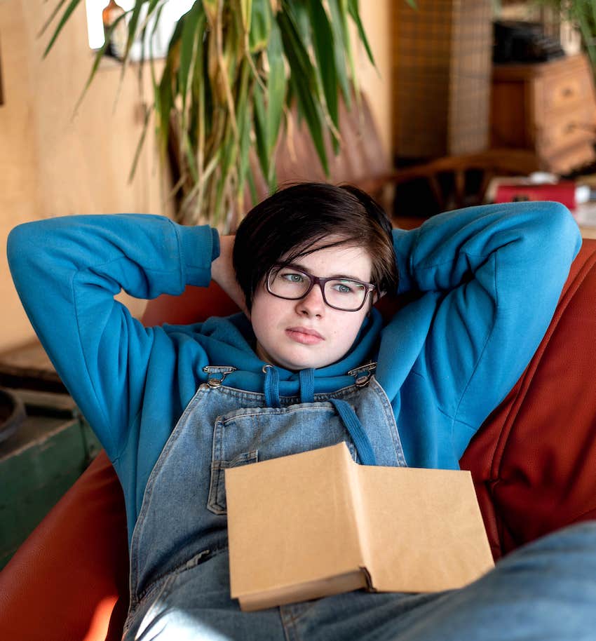 lying comfortably in an armchair with a book