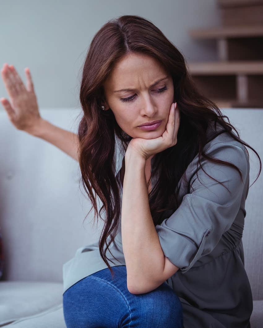 woman gestures to stop and turns away