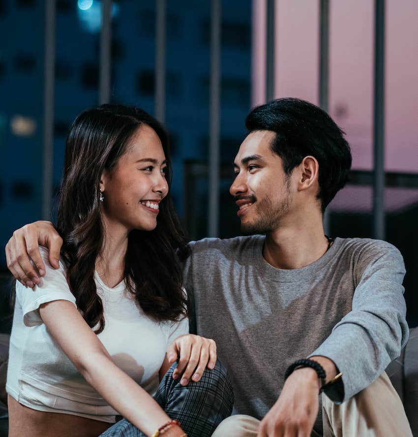 boyfriend embraces girlfriend shoulder looking in her eyes and talking