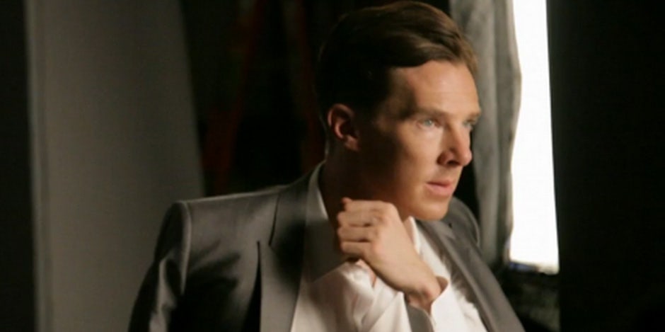 The newly engaged Benedict Cumberbatch wearing a grey and white suit, looking out a window