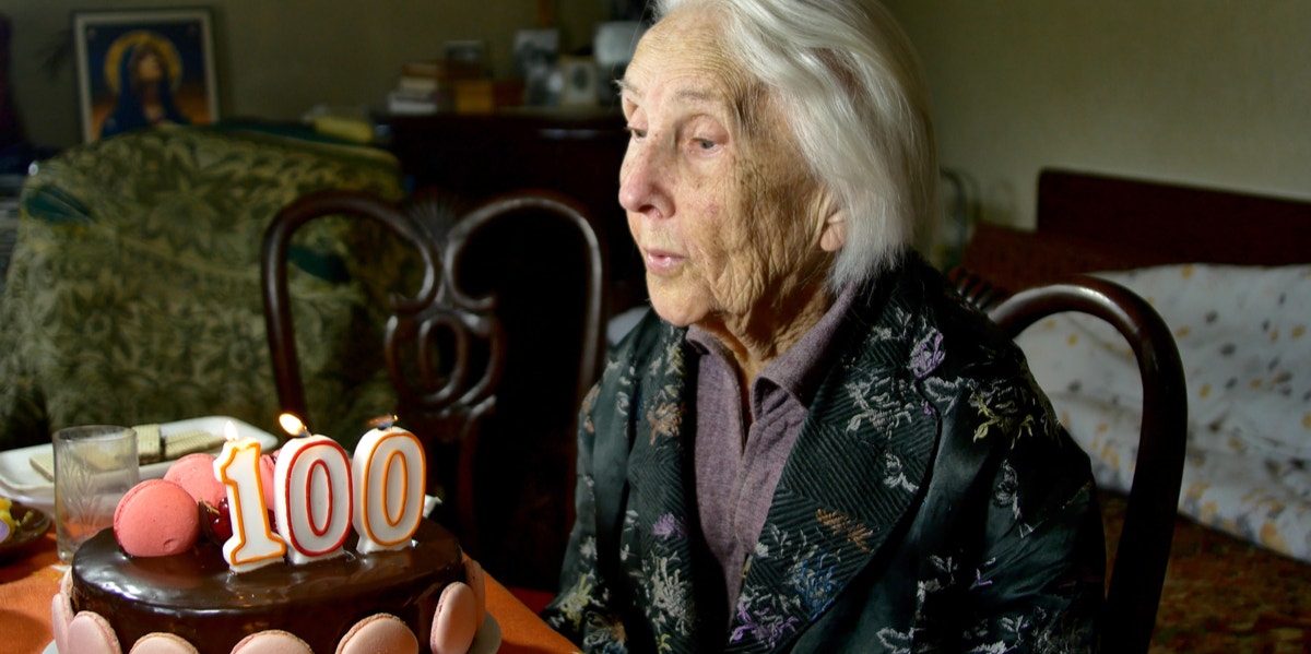 How To Live A Long Life - Advice From People Over 100 Years Old how to live a long life 100-year-old woman blowing birthday candle.