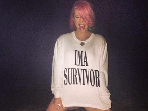Kesha on the beach wearing an "I'm A Survivor" shirt post-rehab