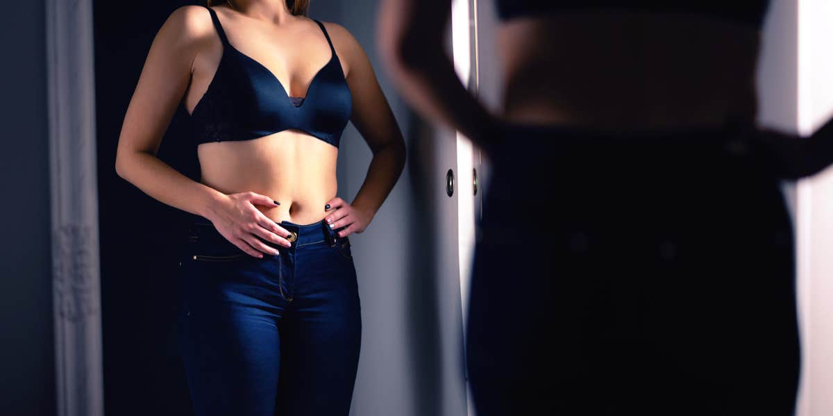 woman inspecting stomach