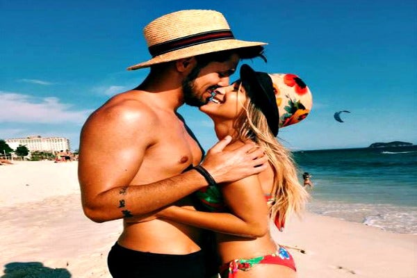 Couple in hats at the beach.