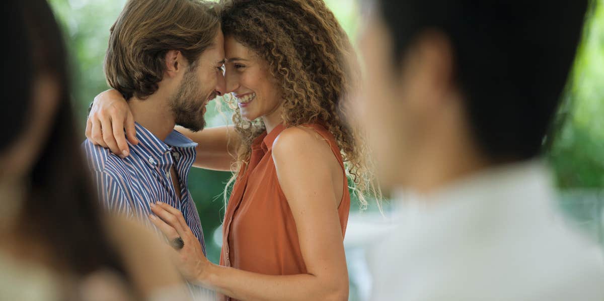 Alarming Relationship Issues That Are Actually Totally Normal hugging at party couple