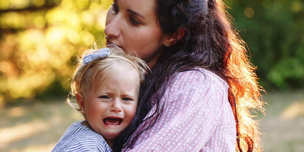 mom holding toddler throwing tantrum