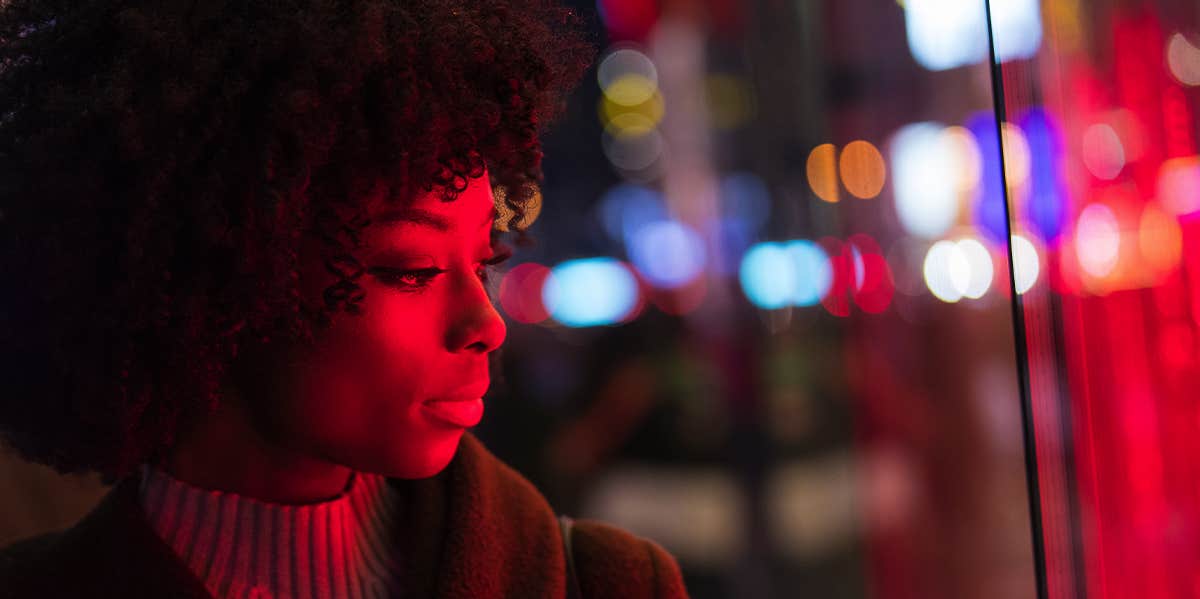 Relatable Truths About Being Single Nobody Talks About woman at night looking at neon sign