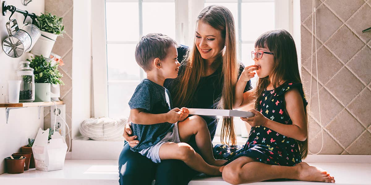 mom and two kids sitting in kitchen