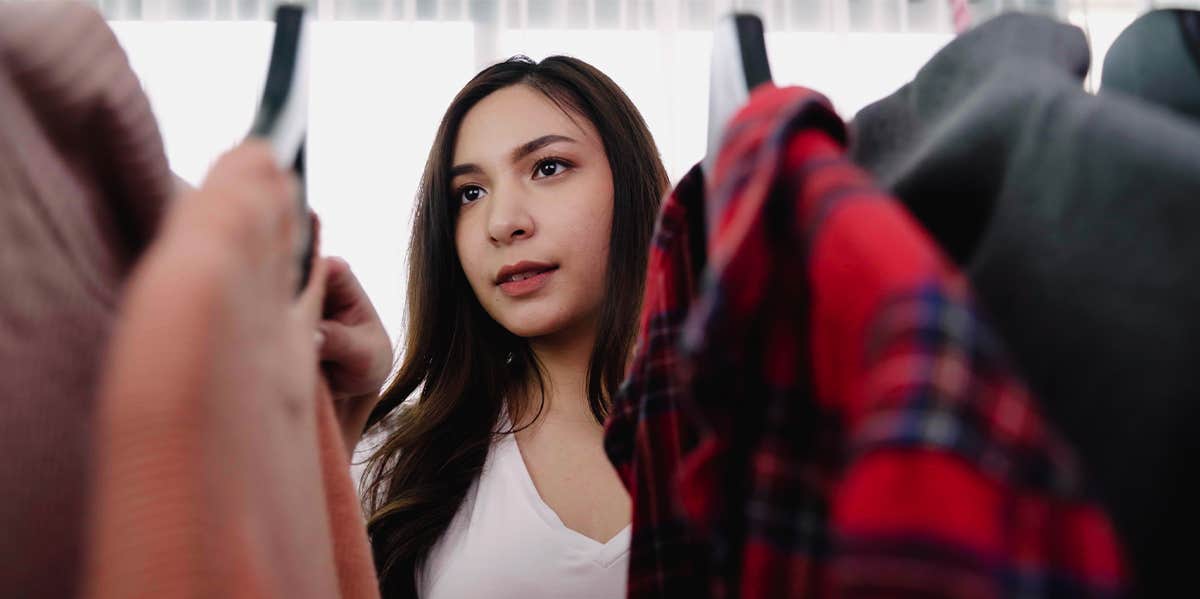 10 Reasons You Still Have Your Ex's Old Clothes woman looking through clothes