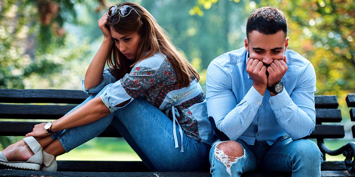 unhappy man and woman sitting on bench