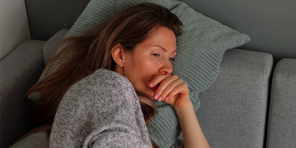 woman lying on coach emotionally exhausted