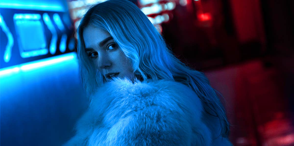 Signs You're A Good Girl Who Knows How To Be Bad woman looking back in blue light