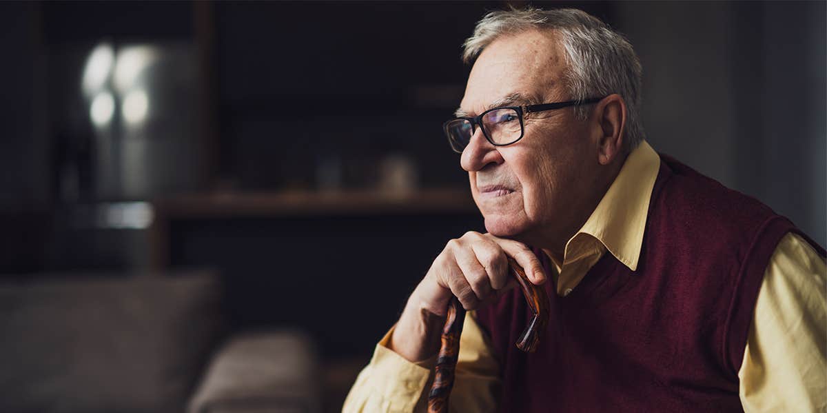 elderly man sitting with cane