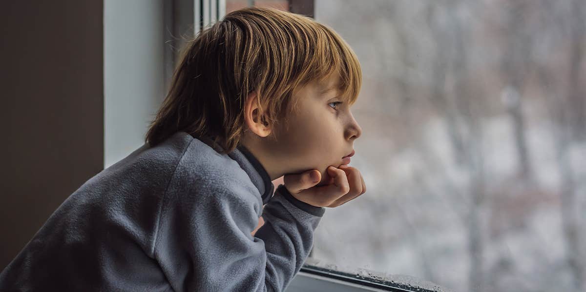 lonely boy looking out window