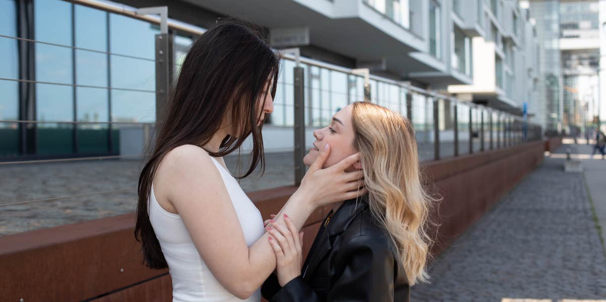 one woman holding another woman's face 