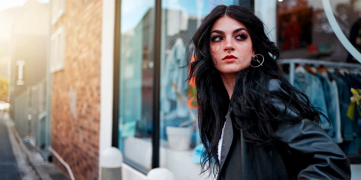 confident woman standing by storefront