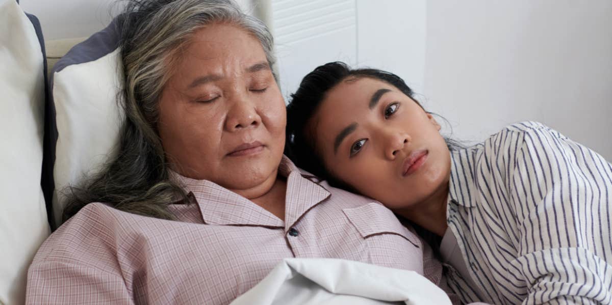 adult daughter hugging mom in bed