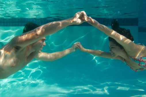 couple holding hands under water couple holding hands under water