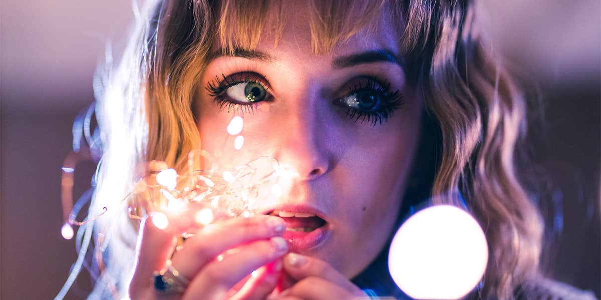 girl holding fairy lights