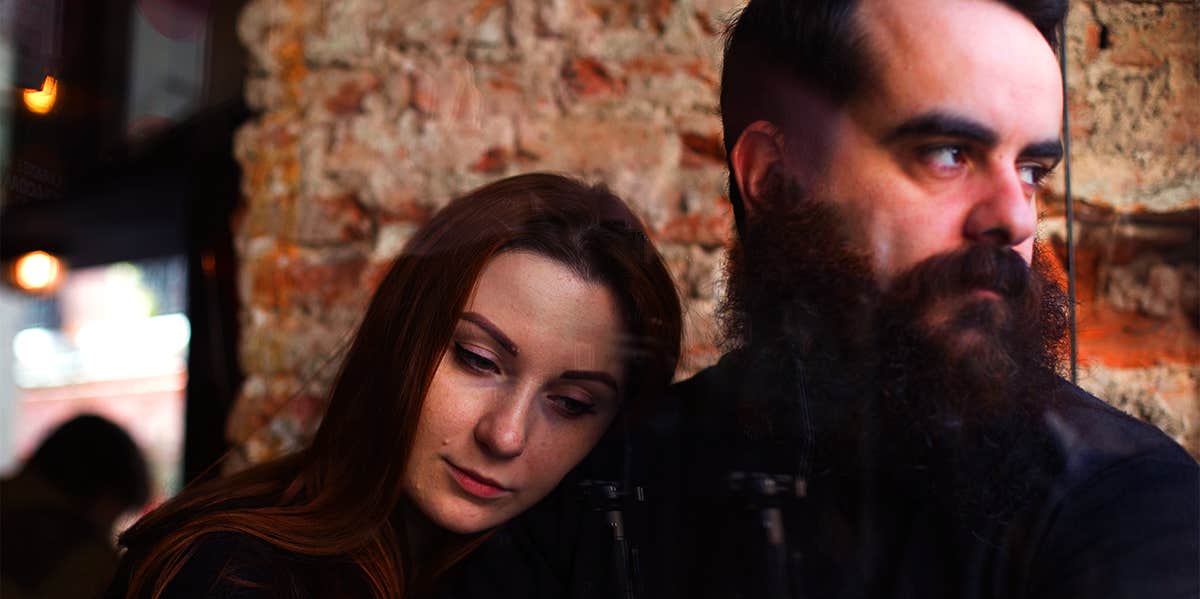 woman leaning on man while sitting at restaurant