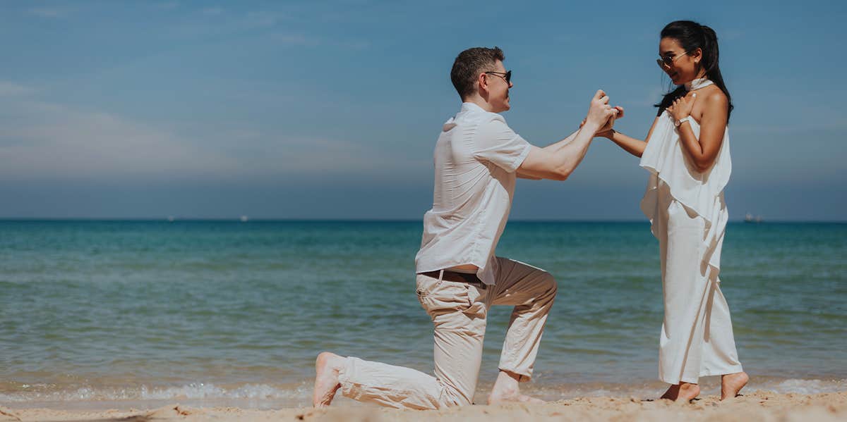 man proposing to woman on the beach