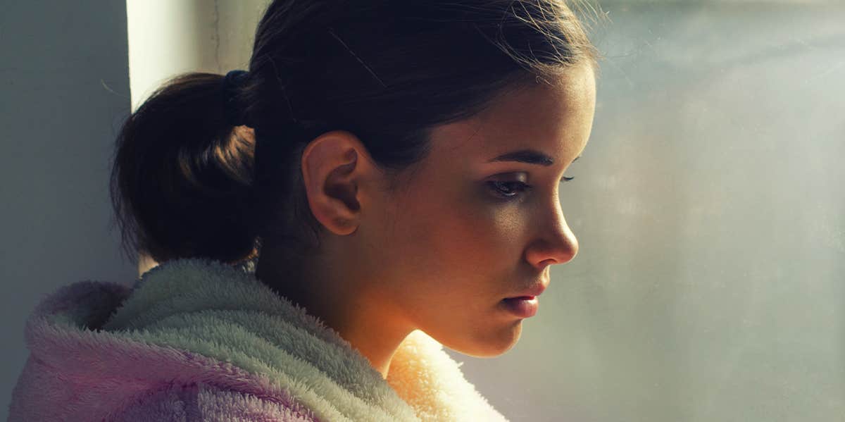 woman sitting by window thinking