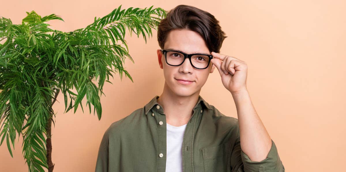 man standing next to plant