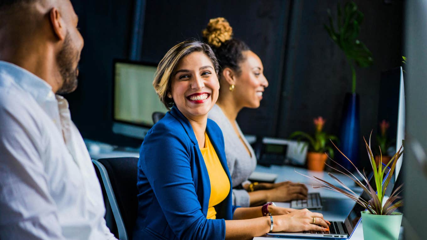 woman working on computer and smiling 