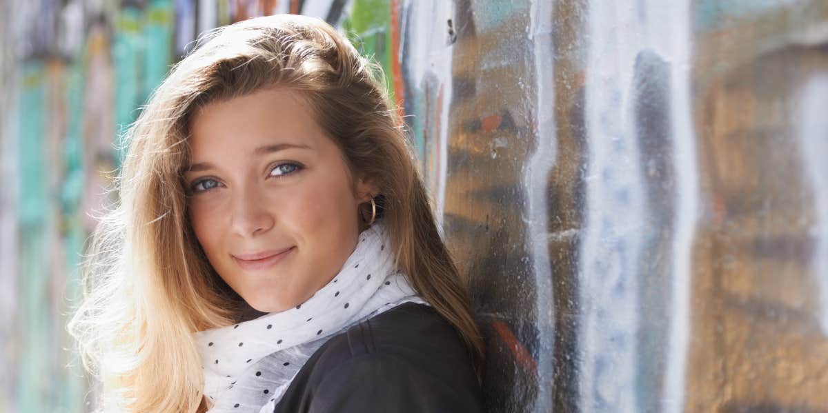 Harsh Signs You're Burned Out By Love (And Need To Take A Break) woman leaning on wall