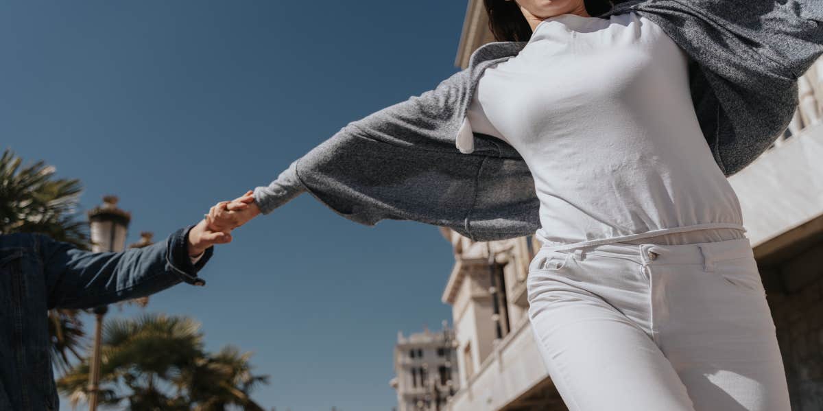 Harsh Signs He's Not Into You Anymore couple pulling hands apart