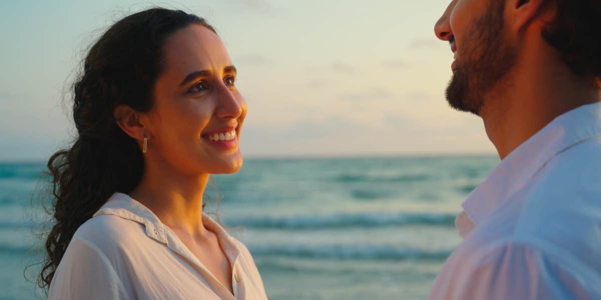 Signs He's Only Using You For His Own Validation woman looking at man by the ocean