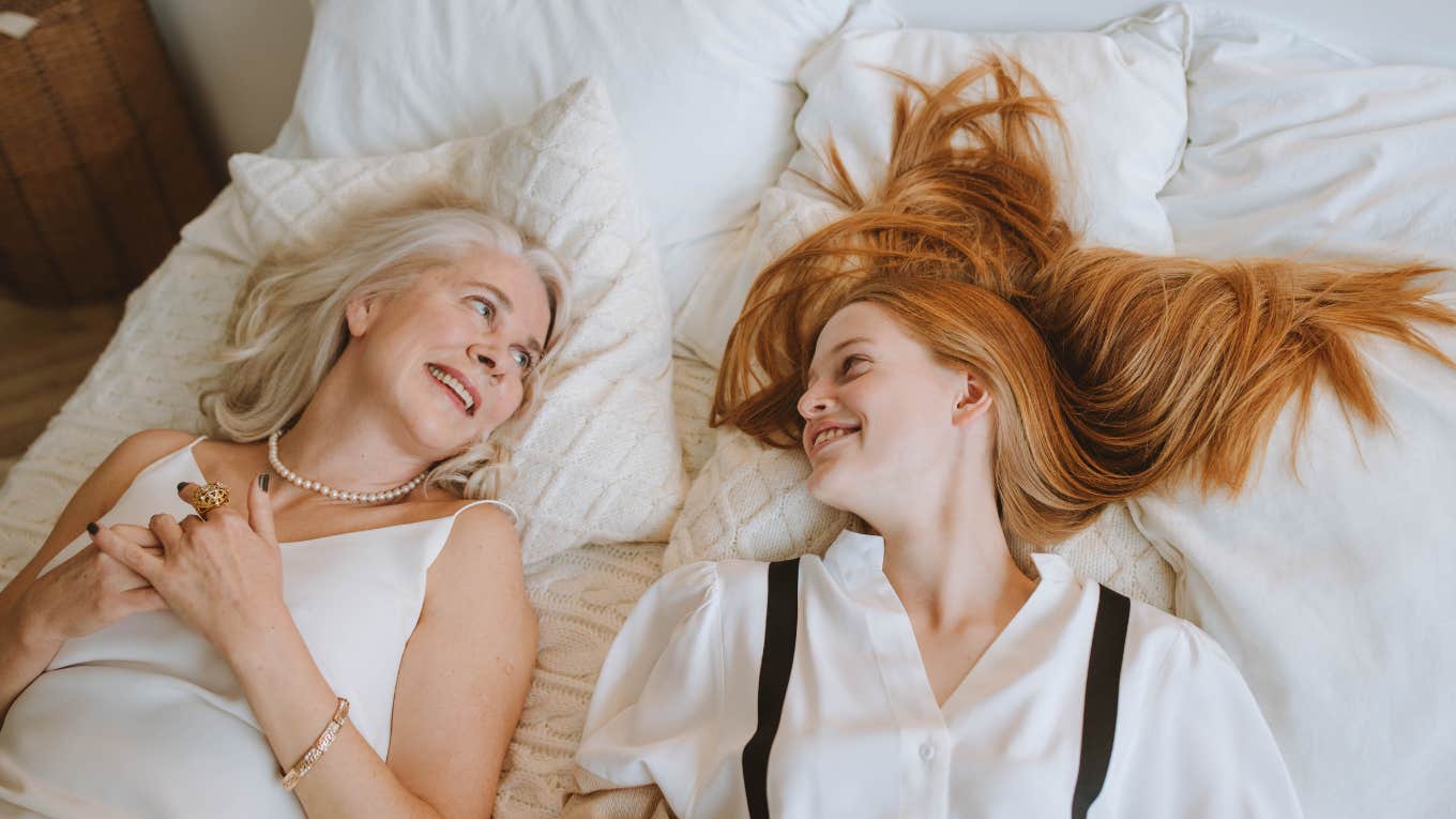 mom and daughter lying on a bed